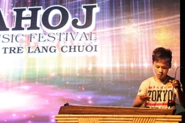 Bé Ba Dương với tiết mục độc tấu đàn bầu ''Việt Nam quê hương tôi.'' (Ảnh: Trần Quang Vinh/Vietnam+)