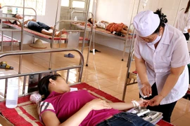 Bác sỹ Trung tâm Y tế huyện Yên Bình chăm sóc cho nạn nhân bị ngộ độc thực phẩm. (Ảnh: Trung Kiên/TTXVN)