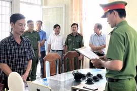 Ông Nguyễn Thái Hưng (ngoài cùng bên trái) nghe Cơ quan Cảnh sát Điều tra tống đạt các quyết định. (Ảnh: TTXVN phát)