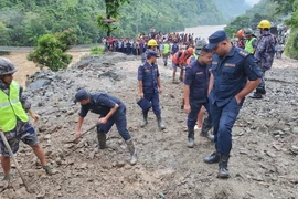 Cảnh sát và lực lượng cứu hộ tìm kiếm người mất tích sau khi 2 xe buýt bị cuốn xuống sông do lở đất tại huyện Chitwan, Nepal. (Ảnh: THX/TTXVN)