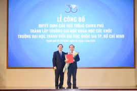 Phó Giáo sư, Tiến sỹ Huỳnh Thành Đạt, Bộ trưởng Bộ Khoa học và Công nghệ trao quyết định thành lập Trường Đại học Khoa học Sức khỏe cho Phó Giáo sư, Tiến sỹ Vũ Hải Quân. (Nguồn: Đại học Quốc gia Thành phố Hồ Chí Minh)