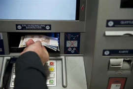 Người dân rút tiền tại cây rút tiền tự động (ATM) ở Berlin, Đức. (Ảnh: AFP/TTXVN)