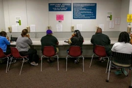 Người lao động sử dụng dịch vụ ngân hàng số bảo hiểm thất nghiệp tại văn phòng phát triển việc làm ở Sacramento, bang California (Mỹ). (Ảnh: AP/TTXVN)