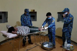 Bác sỹ sơ cứu cho một thuyền viên gặp nạn. (Ảnh: Nguyễn Dũng/TTXVN)