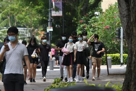 Người dân đeo khẩu trang phòng lây nhiễm COVID-19 tại Singapore. (Ảnh: THX/TTXVN)