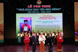 Trưởng Ban dân vận Trung ương Trương Thị Mai và Chủ tịch Ban chấp hành trung ương Hội Nông dân Việt Nam Thào Xuân Sùng trao Giấy chứng nhận và Kỷ niệm chương cho các nhà khoa học. (Ảnh: Hoàng Hiếu/TTXVN)