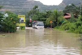 Nước lũ ngập lối đi dân sinh và nhà dân tại thành phố Nha Trang. (Ảnh: Phan Sáu/TTXVN)
