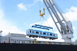 Toa xe đầu tiên của đoàn tàu số 4 được cẩu khỏi tàu vận chuyển Pulang Tala. (Ảnh: Tiến Lực/TTXVN)