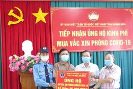 Phó Chủ tịch Ủy ban MTTQ tỉnh Khánh Hòa Cao Ngọc Tâm tiếp nhận tiền ủng hộ kinh phí mua vaccine. (Ảnh: Phan Sáu/TTXVN)