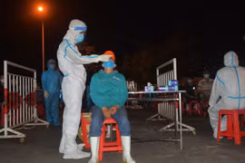 Nhân viên y tế lấy mẫu xét nghiệm cho người dân Cảng cá Thọ Quang ngay 15/5. (Ảnh: Văn Dũng/TTXVN)