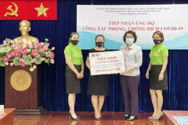 Bà Tô Thị Bích Châu, Chủ tịch Ủy ban MTTQ Việt Nam Thành phố Hồ Chí Minh (giữa) tiếp nhận kinh phí ủng hộ mua vaccine phòng, chống COVID-19 từ đại diện các doanh nghiệp, tổ chức. (Ảnh: Xuân Khu/TTXVN)
