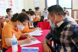 Nhân viên y tế Bệnh viện Đa khoa tỉnh Lạng Sơn hướng dẫn nhân viên, lái xe làm việc tại Cửa khẩu Tân Thanh khai báo trước khi tiêm vắc xin COVID-19. (Ảnh: Thái Thuần/TTXVN)