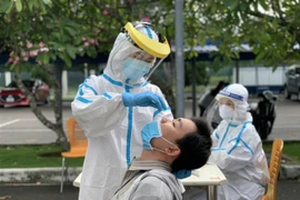 Các y bác sỹ Trung tâm kiểm soát bệnh tật Thành phố Hồ Chí Minh và Quận 7 thực hiện xét nghiệm sàng lọc COVID-19 ngẫu nhiên cho công nhân ở Khu chế xuất Tân Thuận. (Ảnh: Thanh Vũ/TTXVN)