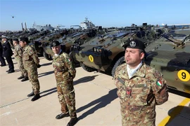 Binh sỹ Italy bên các thiết bị quân sự tại lễ chuyển giao quyền tiếp quản cho Libya tại căn cứ quân sự ở Tripoli. (Ảnh: AFP/TTXVN)