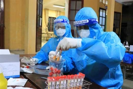 Lấy mẫu xét nghiệp cho người dân tại thôn Giang Liễu, xã Phương Liễu, huyện Quế Võ, Bắc Ninh, trong đêm 4/6. (Ảnh: Thanh Thương/TTXVN)