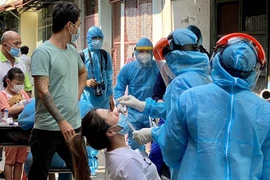 Tiến hành lấy mẫu xét nghiệm virus COVID-19 cho người dân trong khu vực bị phong tỏa tại TP.HCM. (Ảnh: Hồng Giang/TTXVN)