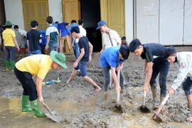 Người dân thị xã Nghĩa Lộ tích cực dọn dẹp, vệ sinh môi trường, nhà cửa, đường xá sau mưa lũ. (Ảnh: Văn Tý/TTXVN)