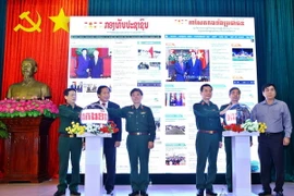 Đại biểu thực hiện nghi thức khai trương báo Quân đội Nhân dân điện tử tiếng Lào và tiếng Khmer. (Ảnh: Minh Quyết/TTXVN)