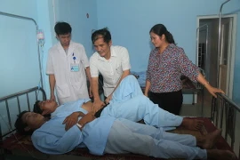  Lãnh đạo huyện Vị Xuyên thăm hỏi các bệnh nhân trong vụ ngộ độc. (Ảnh: Minh Tâm/TTXVN)