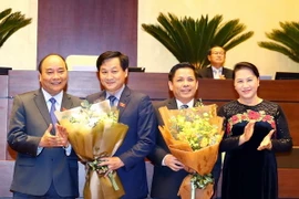Thủ tướng Nguyễn Xuân Phúc và Chủ tịch Quốc hội Nguyễn Thị Kim Ngân tặng hoa chúc mừng Bộ trưởng Bộ Giao thông Vận tải Nguyễn Văn Thể và Tổng Thanh tra Chính phủ Lưu Minh Khái. (Ảnh: Thống Nhất/TTXVN)