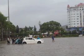 Cứu hộ xe ôtô bị chết máy do ngập nước. (Ảnh: Hoa Mai/TTXVN)