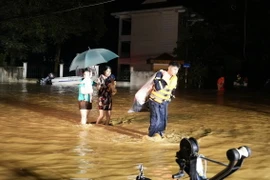 Lực lượng công an thành phố Yên Bái giúp người dân phường Hồng Hà di chuyển ra khỏi khu vực ngập úng trong đêm ngày 8/9. (Ảnh: TTXVN phát)