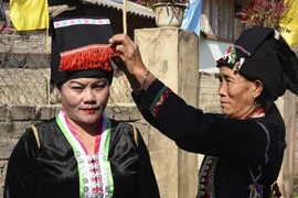 Chiếc khăn đội đầu không chỉ để che nắng, che mưa mà còn giúp khuôn mặt người phụ nữ dân tộc Cống thêm tươi tắn, sinh động. (Ảnh: Xuân Tư/ TTXVN)