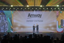 Ông Huỳnh Thiên Triều, Tổng Giám đốc Amway Việt Nam (bên trái) vinh dự được trao tặng phiên bản vàng của Cúp Harmonia với thành tích 5 năm đạt giải thưởng HR Asia - Nơi làm việc tốt nhất châu Á 2024. (Nguồn: Vietnam+)