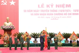 Tổng Bí thư, Chủ tịch nước Tô Lâm gắn Huân chương Hồ Chí Minh lên lá cờ truyền thống của Tổng cục Kỹ thuật (Ảnh: Lâm Khánh/TTXVN)