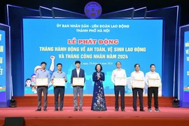 Phó Chủ tịch Ủy ban Nhân dân thành phố Hà Nội Vũ Thu Hà trao khen thưởng cho tập thể, cá nhân có thành tích trong công tác an toàn vệ sinh lao động. (Ảnh: TTXVN phát)
