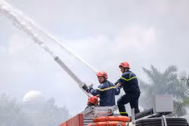 Phun nước từ xe chữa cháy để dập lửa. (Ảnh: Thanh Liêm/TTXVN) 