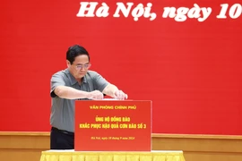 Thủ tướng Phạm Minh Chính ủng hộ đồng bào khắc phục hậu quả cơn bão số 3. (Ảnh: Dương Giang/TTXVN)
