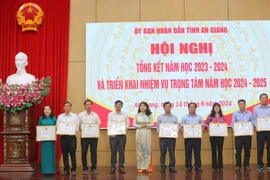 Giám đốc Sở Giáo dục và Đào tạo tỉnh An Giang Trần Thị Ngọc Diễm tặng giấy khen của Sở Giáo dục và Đào tạo tỉnh An Giang cho các tập thể, cá nhân có thành tích xuất sắc trong năm học 2023-2024. (Ảnh: Công Mạo/TTXVN)