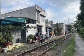 Người dân sống tại khu vực Km1697+150 (phường Trung Dũng, thành phố Biên Hoà, Đồng Nai) di chuyển sát đường sắt không có lan can bảo vệ tiềm ẩn nguy cơ mất an toàn giao thông. (Ảnh: Lê Xuân/TTXVN)