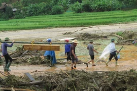 Đưa thi thể được tìm thấy sau cơn lũ dữ ở làng Nủ (Lào Cai) về an táng. (Ảnh: Hồng Ninh/TTXVN)