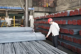 Cán bộ kỹ thuật Công ty cổ phẩn Gang thép Thái Nguyên kiểm tra thép cán trước khi xuất xưởng. (Ảnh: Hoàng Nguyên/TTXVN) 