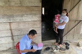 Trung tâm Kiểm soát Bệnh tật tỉnh Đắk Lắk kiểm tra thông tin tiêm chủng phòng bệnh viêm não Nhật Bản tại khu vực ghi nhận trường hợp mắc bệnh tại xã Cư Prao, huyện M'Đrắk (Đắk Lắk). (Ảnh: TTXVN phát)