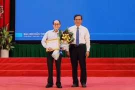 Phó Giáo sư, Tiến sỹ Trần Trung Tính, Hiệu trưởng Trường Đại học Cần Thơ trao giấy khen và học bổng toàn phần cho cụ Nguyễn Tấn Thành. (Ảnh: Ánh Tuyết/ TTXVN)