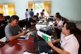 Người dân vay vốn chính sách từ Ngân hàng Chính sách xã hội trong phiên giao dịch tổ chức hàng tháng tại Điểm giao dịch xã La Ngà, huyện Định Quán, tỉnh Đồng Nai. (Ảnh: Hồng Đạt/TTXVN)