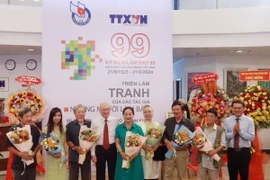Tặng hoa tri ân cho nhóm tác giả có tác phẩm trưng bày tại Triển lãm. (Ảnh: Thu Hương/ TTXVN)