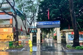 Nhân viên Công ty trách nhiệm hữu hạn một thành viên Thoát nước Hà Nội luôn ứng trực tiêu thoát nước tại các điểm thi. (Ảnh: TTXVN phát)