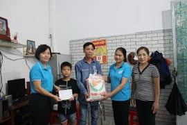 Hội Liên hiệp Phụ nữ phường Thắng Nhì trao tiền hỗ trợ của "Mẹ đỡ đầu" và gạo từ nhà hảo tâm cho em Đoàn Hoàng Hùng, học sinh trường Tiểu học Nguyễn Thái Học (thành phố Vũng Tàu), mồ côi mẹ. (Ảnh: Hoàng Nhị/ TTXVN)