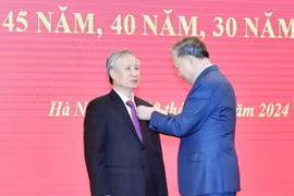 Tổng Bí thư Tô Lâm trao Huy hiệu 45 năm tuổi Đảng cho đồng chí Trần Quốc Vượng, nguyên Ủy viên Bộ Chính trị , nguyên Thường trực Ban Bí thư, Trưởng Ban Chỉ đạo 110. (Ảnh: Thống Nhất/TTXVN)