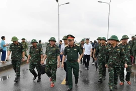 Trung tướng Phạm Đức Duyên, Bí thư Đảng ủy, Chính ủy Quân khu 2 và đại diện các đơn vị khảo sát vị trí lắp cầu phao. (Ảnh: TTXVN phát)