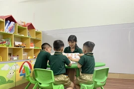 Cô Nguyễn Thị Mai, Giám đốc Trung tâm Hỗ trợ giáo dục hòa nhập trẻ tự kỷ Hoàng Đức (thành phố Biên Hòa, Đồng Nai) cùng chơi với trẻ tự kỷ trong tiết can thiệp cá nhân. (Ảnh: Lê Xuân/TTXVN)