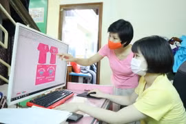 Chị Nghiêm Thị Thu Hường, Chủ nhiệm Cơ sở May Công nghiệp của người khuyết tật tỉnh Lạng Sơn hướng dẫn học viên thiết kế quần áo trên máy tính. (Ảnh: Anh Tuấn/ TTXVN)