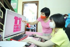 Chị Nghiêm Thị Thu Hường, Chủ nhiệm Cơ sở May Công nghiệp của người khuyết tật tỉnh Lạng Sơn hướng dẫn học viên thiết kế quần áo trên máy tính. (Ảnh: Anh Tuấn/ TTXVN)