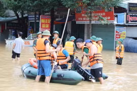 Các lực lượng chức năng sử dụng mọi phương tiện để vận chuyển nhu yếu phẩm đến với người dân bị ngập sâu tại phường Quang Vinh, thành phố Thái Nguyên. (Ảnh: Hoàng Nguyên/TTXVN)