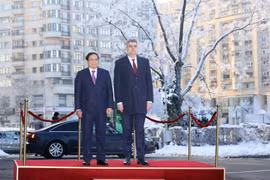 Thủ tướng Phạm Minh Chính và Thủ tướng Romania Ion-Marcel Ciolacu nghe quân nhạc cử Quốc thiều hai nước. (Ảnh: Dương Giang/TTXVN)