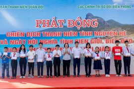 Các đại biểu tặng quà cho các cháu học sinh có hoàn cảnh khó khăn vượt khó, học giỏi. (Ảnh: Huỳnh Sơn/TTXVN)